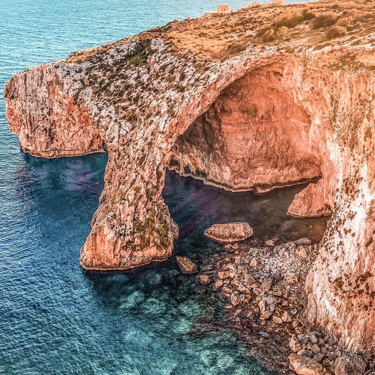 The natural limestone arch and blue sea at the Blue Grotto, Malta