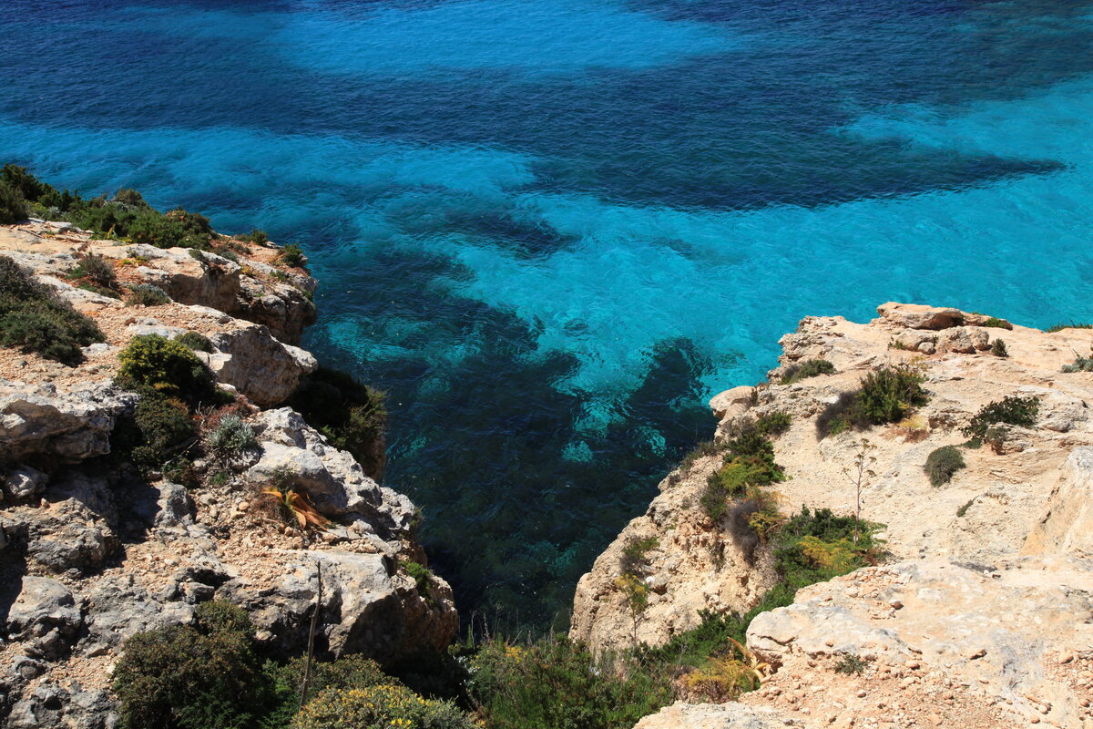 Clear turquoise water and rocky shoreline at Comino’s Blue Lagoon